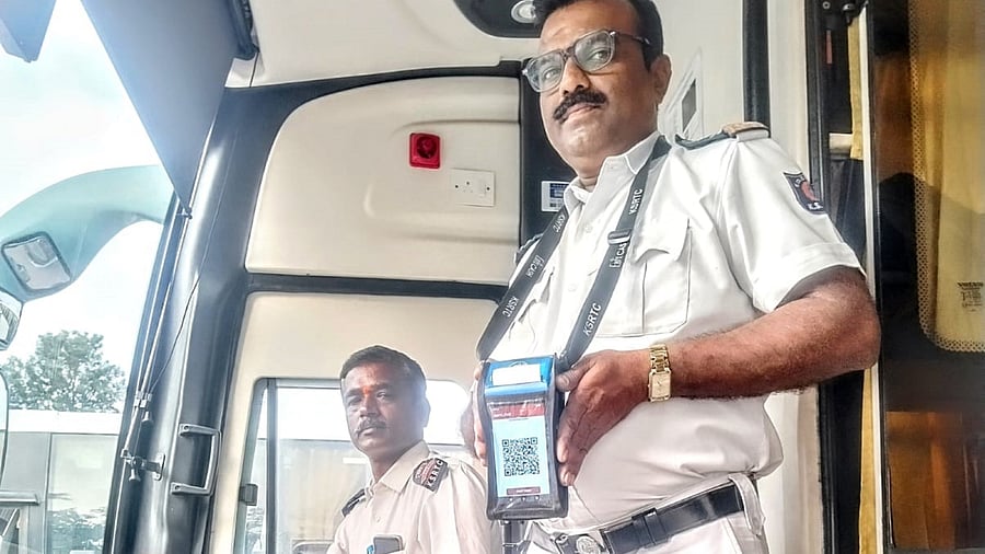 A KSRTC bus conductor displays a smart Electronic Ticketing Machine (ETM) that supports all digital payments.