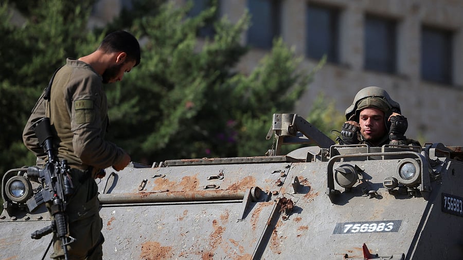 <div class="paragraphs"><p>Israeli soldiers work on uploading a military vehicle onto a truck on the second day of the ceasefire between Israel and Hezbollah, near a road close to the Israel-Lebanon border.</p></div>