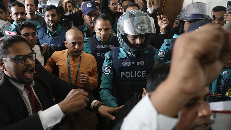 <div class="paragraphs"><p>Chinmoy Krishna Das, a Hindu leader associated with the International Society for Krishna Consciousness (ISKCON), who faces several charges, is escorted by the police at the Chattogram Metropolitan Magistrate Court, in Chattogram, Bangladesh.</p></div>