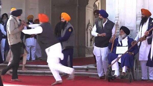 <div class="paragraphs"><p>People catch a man who allegedly opened fire at Shiromani Akali Dal leader Sukhbir Singh Badal while the latter was performing the duty of 'sewadar' outside the Golden Temple, in Amritsar, Wednesday, Dec. 4, 2024. </p></div>