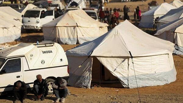 <div class="paragraphs"><p>Displaced people who fled from Aleppo countryside, sit together near tents in Tabqa.</p></div>