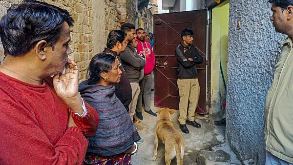 <div class="paragraphs"><p>Police personnel and others at a house at Neb Sarai area where a middle-aged couple and their daughter were found dead, in New Delhi, Wednesday, Dec. 4, 2024.</p></div>
