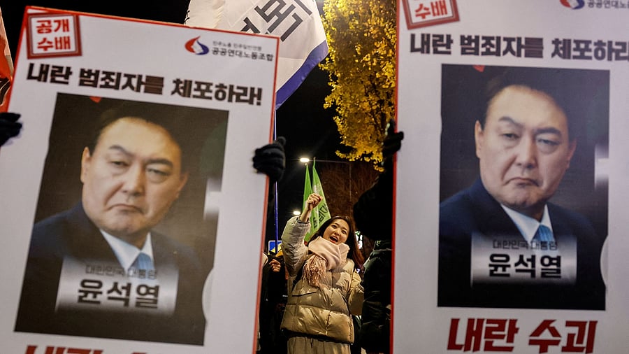 <div class="paragraphs"><p>Protesters hold placards during a candlelight vigil to condemn South Korean President Yoon Suk Yeol's surprise declarations of the failed martial law and to call for his resignation in Seoul, South Korea</p></div>