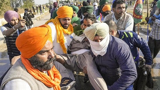 <div class="paragraphs"><p>An injured farmer being carried after teargas shells were lobbed by security personnel to disperse protesting farmers following the commencement of their foot march to Delhi, at Shambhu border in Patiala district, Punjab, Friday, Dec. 6, 2024. A 'jatha' of 101 farmers on Friday began its foot march to Delhi from their protest site at Shambhu border, but was stopped a few metres away by a multilayered barricading.</p></div>