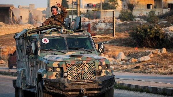 <div class="paragraphs"><p>A rebel led by the Islamist militant group Hayat Tahrir al-Sham stands in the back of a vehicle in al-Rashideen, Aleppo province, Syria.</p></div>