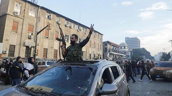 <div class="paragraphs"><p>A rebel fighter gestures from a vehicle as they gather in Homs after Syria's army command notified officers on Sunday that President Bashar al-Assad's 24-year authoritarian rule has ended, a Syrian officer who was informed of the move told Reuters, following a rapid rebel offensive, in Homs, Syria.&nbsp;</p></div>