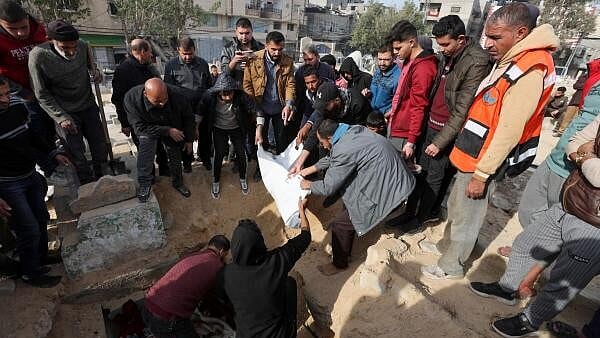 <div class="paragraphs"><p>Mourners bury the body of a Palestinian killed in an Israeli airstrike, amid the Israel-Hamas conflict, at a cemetery in Nuseirat refugee camp in the central Gaza Strip, December 7</p></div>