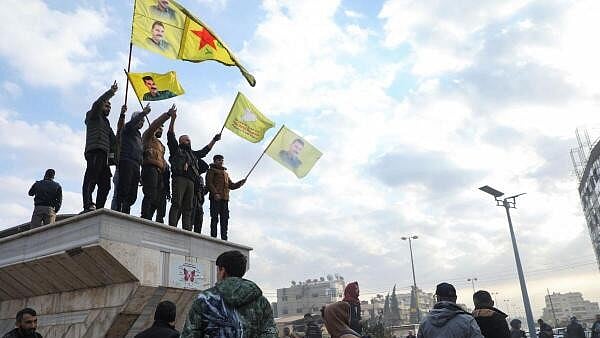 <div class="paragraphs"><p>Men hold flags as people celebrate, after Syrian rebels announced that they have ousted President Bashar al-Assad, in Qamishli, Syria December 8, 2024.</p></div>
