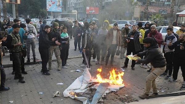 <div class="paragraphs"><p>Rebel fighters gather around a fire lit in materials in Homs after Syria's army command notified officers on Sunday that President Bashar al-Assad's 24-year authoritarian rule has ended.</p></div>