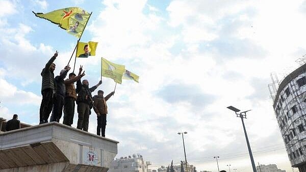 <div class="paragraphs"><p>Men hold flags as people celebrate, after Syrian rebels announced that they have ousted President Bashar al-Assad, in Qamishli, Syria December 8, 2024.</p></div>