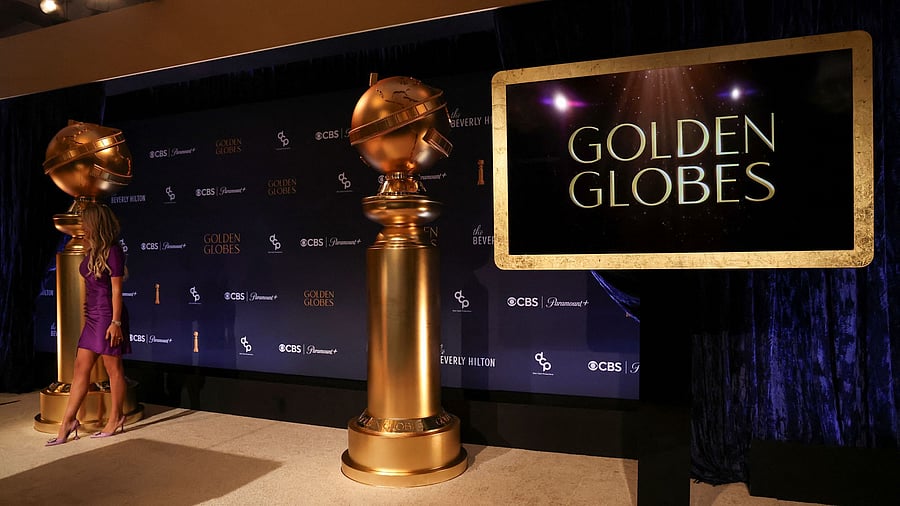 <div class="paragraphs"><p>A woman stands next to Golden Globe statues.&nbsp;</p></div>