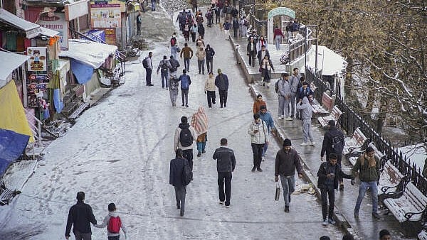 <div class="paragraphs"><p>People walk on a snow covered road after fresh snowfall in Shimla, Himachal Pradesh.</p></div>