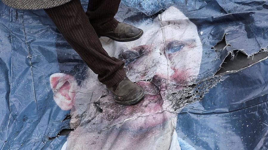 <div class="paragraphs"><p>A man walks on a poster of Bashar al-Assad, after Syrian rebels announced that they have ousted Syria's Bashar al-Assad, in downtown Damascus, Syria December 10, 2024. </p></div>