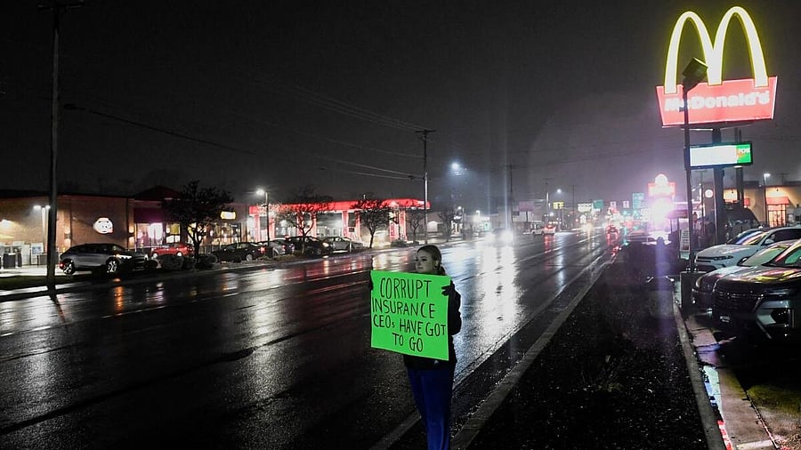 <div class="paragraphs"><p>A person holds a sign while standing on the roadside near the McDonald's restaurant where a suspect in the killing of the CEO of UnitedHealthcare, Brian Thompson, was arrested, in Altoona.</p></div>