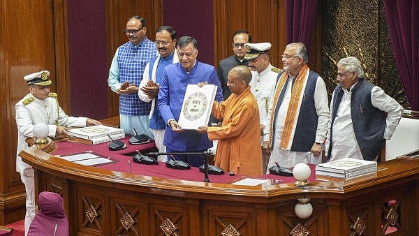 <div class="paragraphs"><p>Chief Minister Yogi Adityanath being presented the original copy of the Indian Constitution by state Assembly Speaker Satish Mahana during the Winter session of the state Legislative Assembly, in Lucknow, on Monday.</p></div>