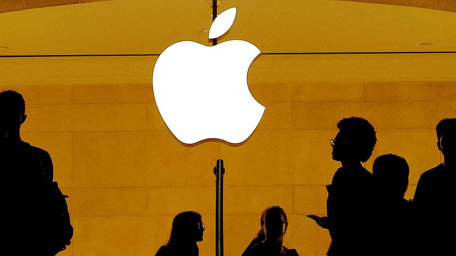 <div class="paragraphs"><p>FILE PHOTO: Customers walk past an Apple logo inside of an Apple store.</p></div>