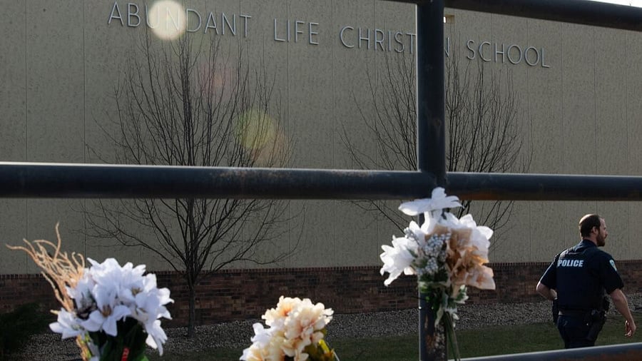 <div class="paragraphs"><p>A police officer passes flowers left in memory of victims a day after a shooting at Abundant Life Christian School, in Madison, Wisconsin, U.S. December 17, 2024.</p></div>