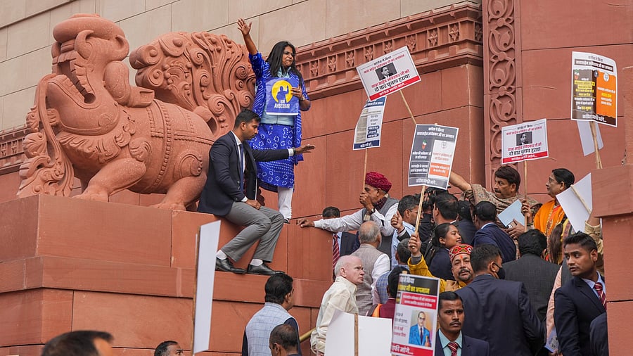 <div class="paragraphs"><p>Congress MPs hold placards during a protest by I.N.D.I.A. bloc at Parliament complex, in New Delhi.</p></div>