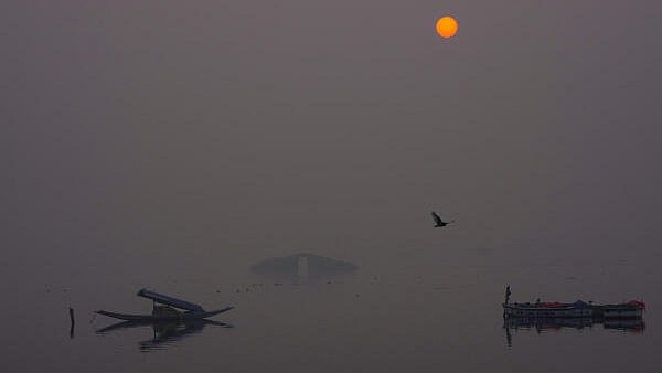 <div class="paragraphs"><p> Boatmen row their 'Shikaras' at Dal Lake on a foggy day, as the sun sets, in Srinagar, Friday, Dec. 20, 2024. The city recorded a minimum temperature of minus 6.2 degrees Celsius, a coldest night of the season so far, ahead of the 'Chillai Kalan', the harshest winter period in Kashmir.</p></div>