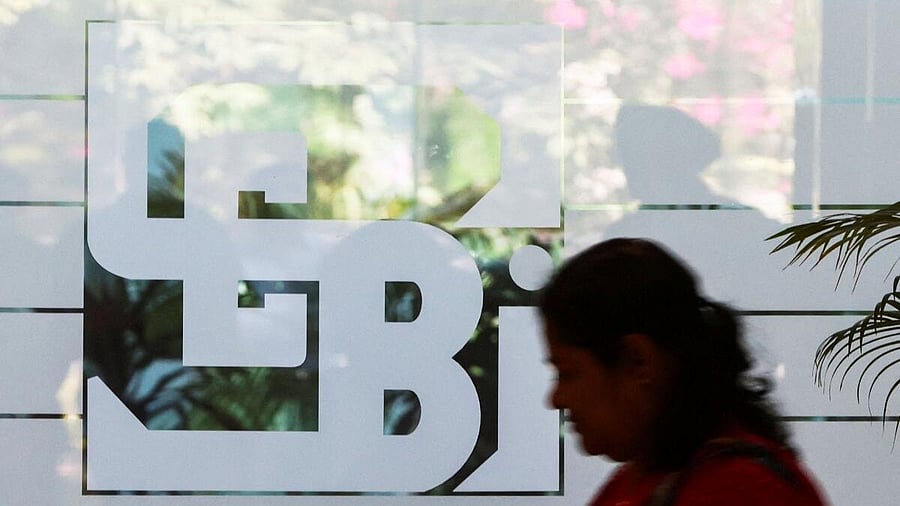 <div class="paragraphs"><p>A woman walks past the logo of the Securities and Exchange Board of India (SEBI), at its headquarters in Mumbai</p></div>