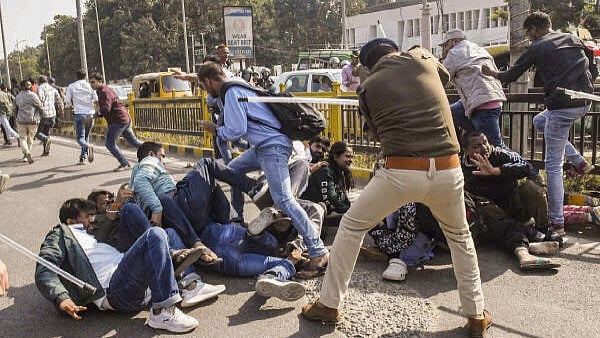 <div class="paragraphs"><p>A police official lathi-charges job aspirants outside the BPSC office in Patna. </p></div>