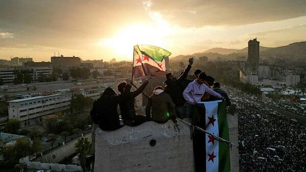 <div class="paragraphs"><p>A drone view shows people waving flags adopted by the new Syrian rulers during celebrations in Umayyad Square, after the ousting of Syria's Bashar al-Assad, in Damascus, Syria,</p></div>