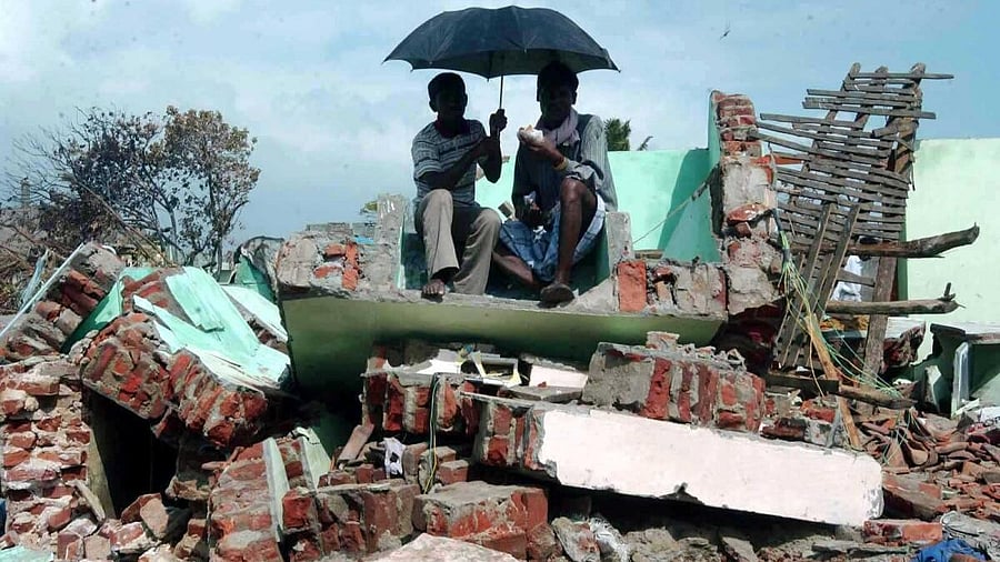 <div class="paragraphs"><p>Locals sit in the wreckage which was once their home at a tsunami-hit village, in Tamil Nadu.</p></div>