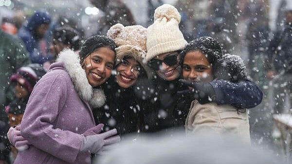 <div class="paragraphs"><p>Visitors take photographs amid season's first snowfall, in Srinagar, Friday, Dec. 27, 2024.</p></div>