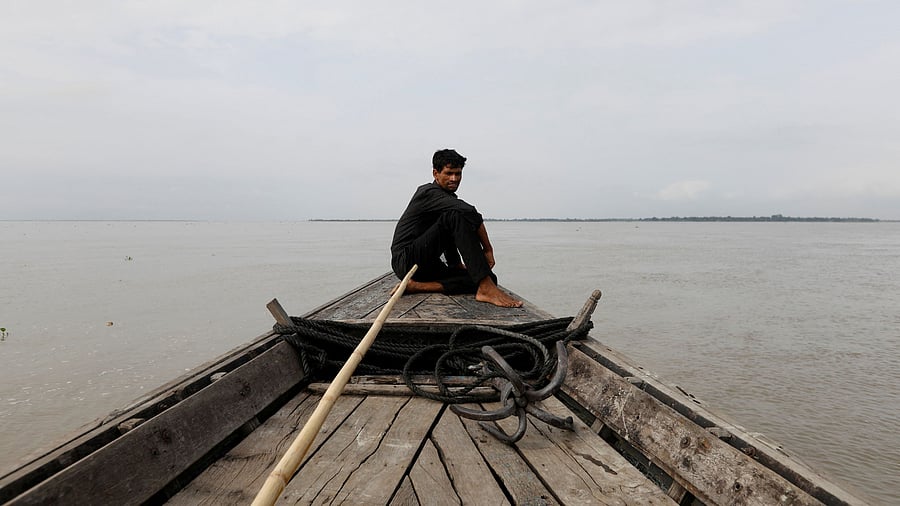 <div class="paragraphs"><p>A man sits in a boat on the waters of the Brahmaputra river near the international border between India and Bangladesh in Dhubri district, in the northeastern state of Assam</p></div>