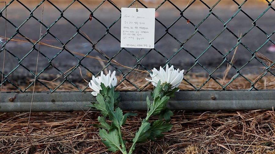 <div class="paragraphs"><p>Flowers and a message of condolence laid by people working at the site where an aircraft went off the runway and crashed, are pictured at Muan International Airport in Muan, South Korea, December 30, 2024.</p></div>