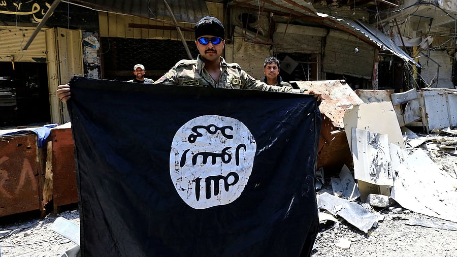 <div class="paragraphs"><p>A man holds an Islamic State militants flag.</p></div>