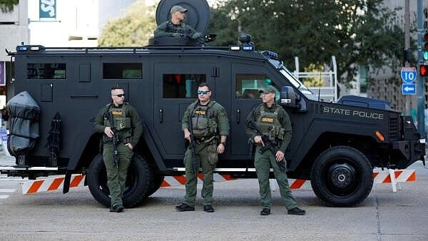 <div class="paragraphs"><p>Louisiana State Police stand guard next to a vehicle</p></div>