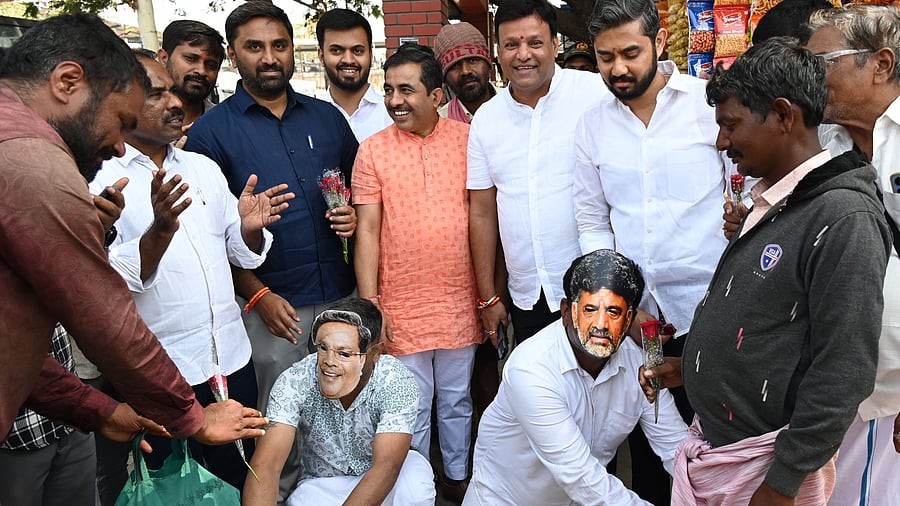 <div class="paragraphs"><p>BJP workers wearing masks of CM Siddaramaiah &amp; his deputy D K Shivakumar fall at men's feet to 'apologise on their behalf', during a protest against bus fare hike at the Majestic bus stand in Bengaluru on Friday. </p></div>