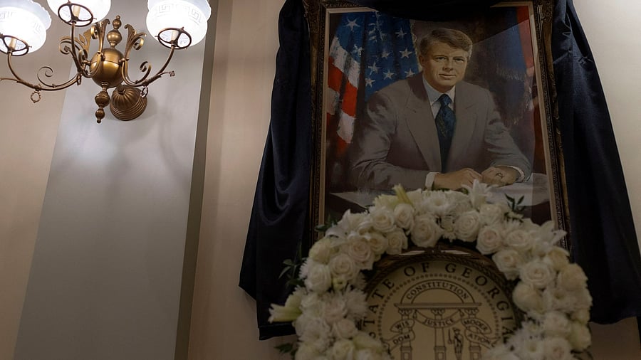 <div class="paragraphs"><p>Black fabric and a floral wreath are displayed on the official state portrait of late former US President Jimmy Carter by Robert Templeton at the Georgia State Capitol building in Atlanta, Georgia, US, January 3, 2025. </p></div>