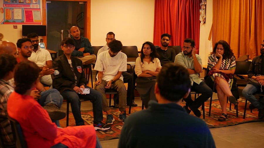 Back view of mature professor giving lecture to large group of college students in the classroom.