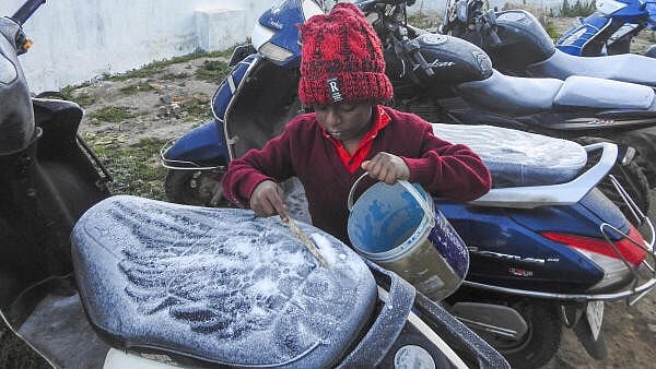 <div class="paragraphs"><p>A child removes frost from a two-wheeler during a cold and foggy winter morning, at Ooty in Nilgiris district, Tamil Nadu</p></div>