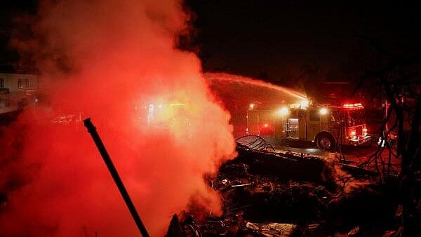 <div class="paragraphs"><p>Firefighters hose down a hotspot at a commercial building that burned down during the Eaton Fire, in Altadena, California, US, January 10, 2025. </p></div>
