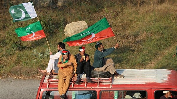 <div class="paragraphs"><p>Supporters of the former Pakistani Prime Minister Imran Khan's party, Pakistan Tehreek-e-Insaf (PTI) sit atop a vehicle as they head towards Islamabad, during an anti-government rally, in Peshawar, Pakistan, November 24, 2024.</p></div>