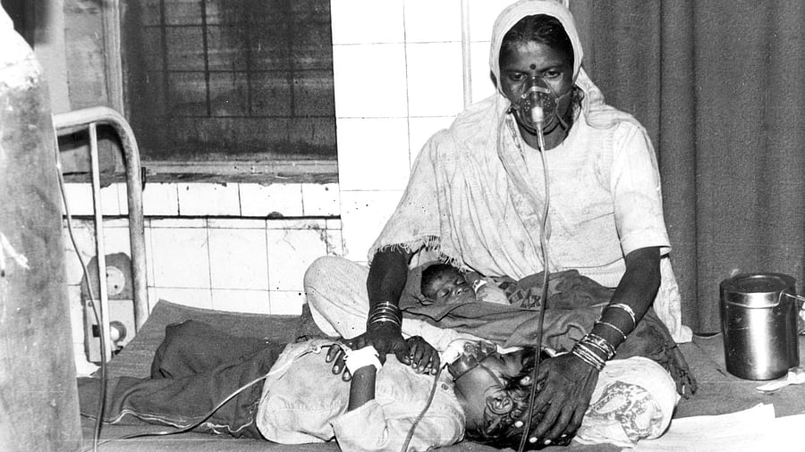 <div class="paragraphs"><p>In this photo dated December 3, 1984, a survivor of the Bhopal gas tragedy is undergoing treatment with her two kids at a local hospital. </p></div>