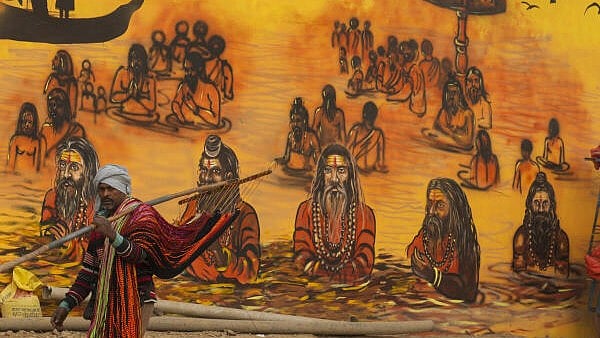 <div class="paragraphs"><p>A devotee walks past a mural ahead of Maha Kumbh Mela 2025, in Prayagraj, Uttar Pradesh, Sunday.</p></div>