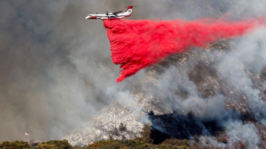 <div class="paragraphs"><p>A plane makes a drop as smoke billows from the Palisades Fire at the Mandeville Canyon, in Los Angeles, California.</p></div>