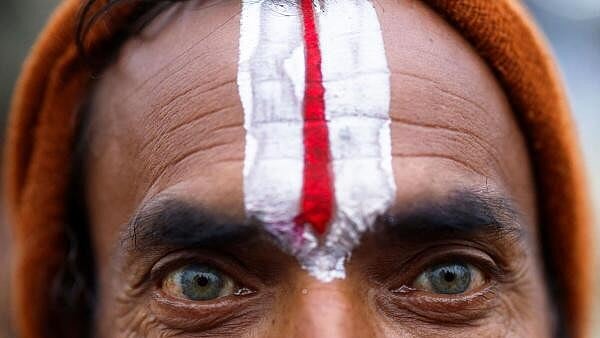 <div class="paragraphs"><p>A Sadhu or a Hindu holy man looks on during the day devotees take a holy dip at Sangam, the confluence of the Ganges, Yamuna and Saraswati rivers, during the "Maha Kumbh Mela", or the Great Pitcher Festival, in Prayagraj.</p></div>