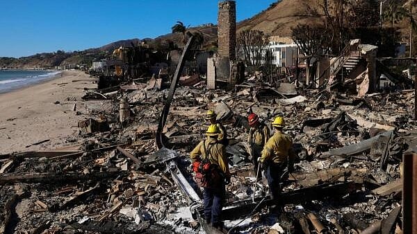 <div class="paragraphs"><p>Firefighters look for hotspots at a home burned-down due to the Palisades Fire, along Pacific Coast Highway in Malibu, California, US.</p></div>