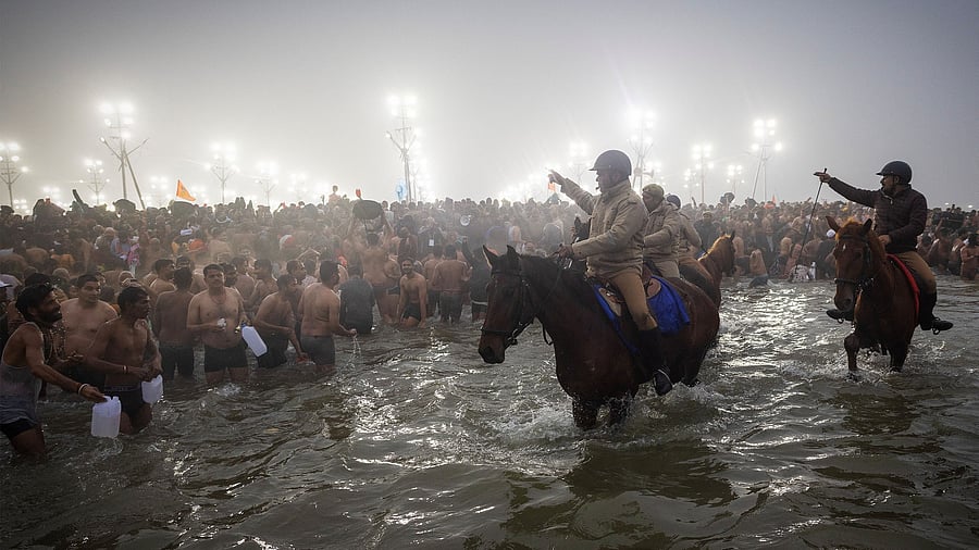 <div class="paragraphs"><p>Policemen on horses remove devotees from the water before the arrival of Naga Sadhus.</p></div>