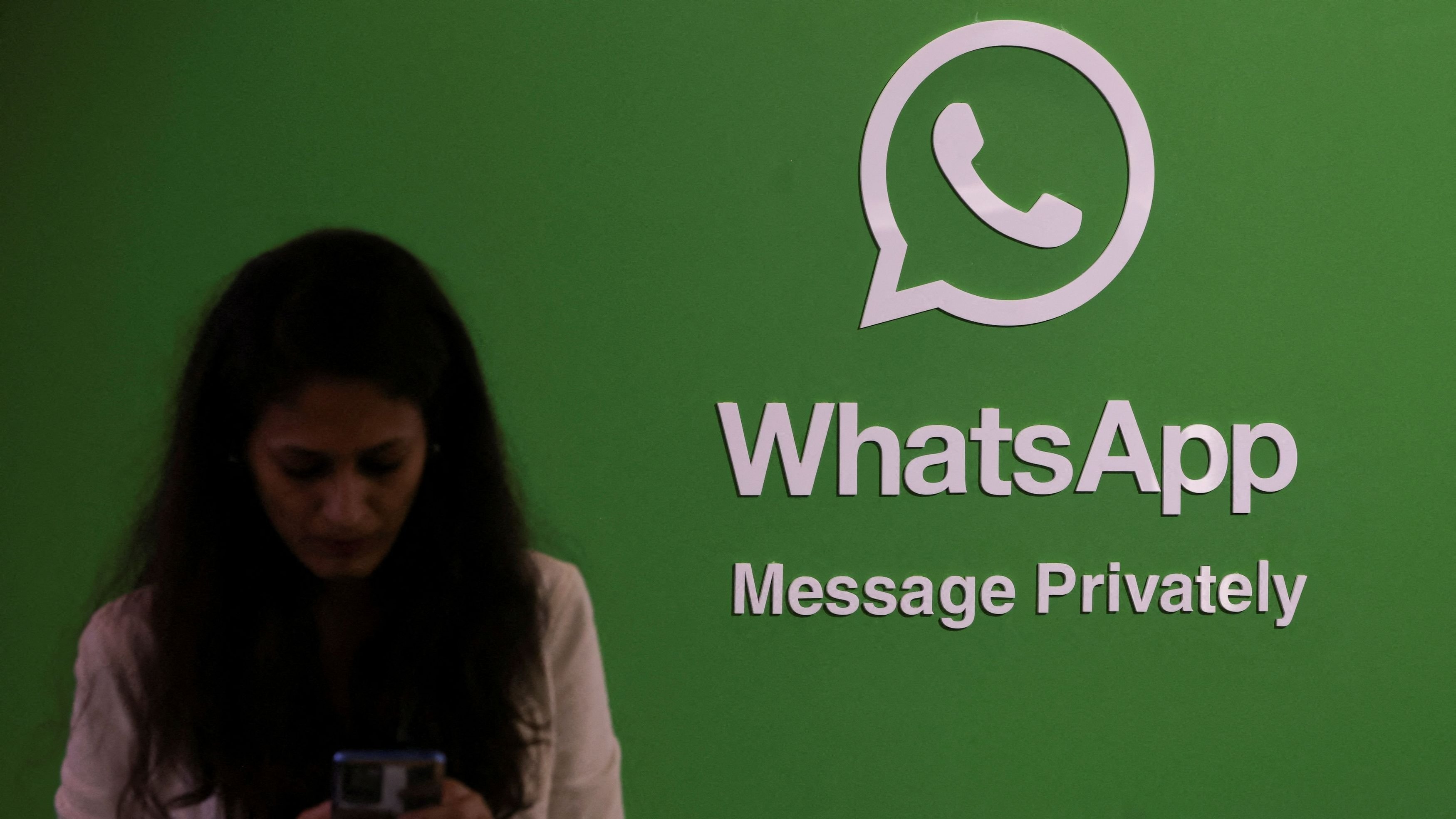<div class="paragraphs"><p>FILE PHOTO: A woman uses her phone next to a logo of the WhatsApp application during Global Fintech Fest in Mumbai.</p></div>