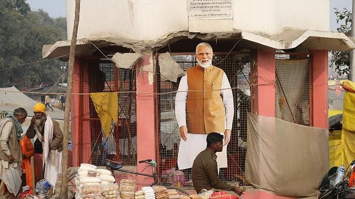 <div class="paragraphs"><p> A police personnel sits in front of a cutout of Prime Minister Narendra Modi at a stall enroute to the sangam at the MahaKumbh 2025, at Prayagraj, Uttar Pradesh, January 13</p></div>