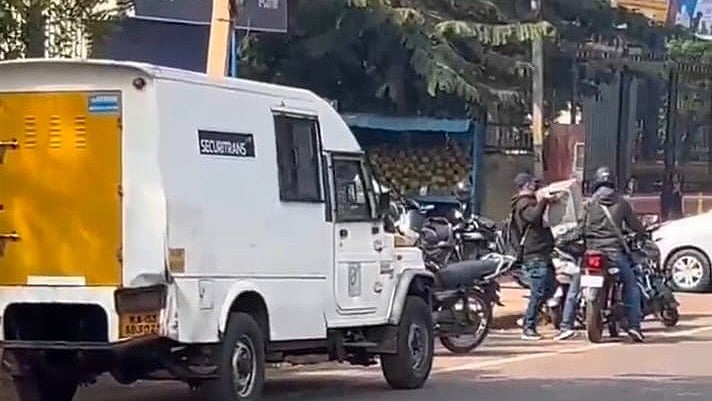 A CCTV grab of unidentified miscreants loading on to a bike the cash trunk they robbed from a ATM cash van in Bidar on Thursday. 