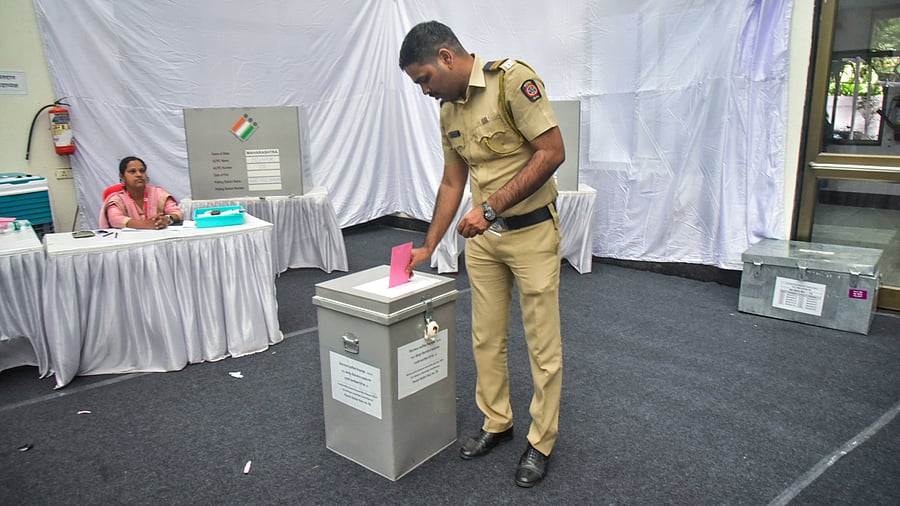 <div class="paragraphs"><p> A police personnel on election duty casts his vote through postal ballot for the Maharashtra Assembly polls, in Navi Mumbai, Maharashtra.</p></div>