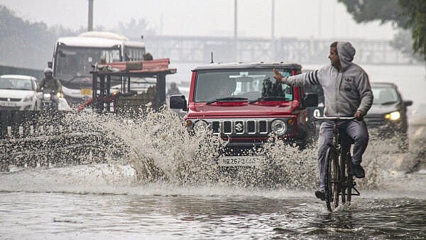 <div class="paragraphs"><p>Vehicles move through a waterlogged service road of the Delhi-Gurugram Expressway after heavy rains, in Gurugram.</p></div>