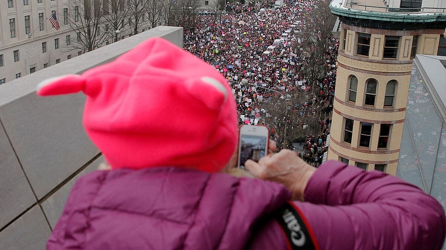 <div class="paragraphs"><p>A woman wearing a pink pussy protest hat takes a photograph of the Women's March on Washington, following the inauguration of US President Donald Trump.</p></div>